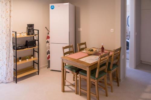 een eetkamer met een tafel en een koelkast bij Elegia Apartment in Mantoúkion