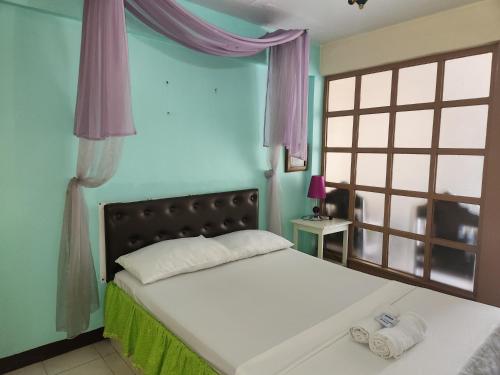 a bedroom with a bed with two towels on it at Country Sampler Inn in Tagaytay