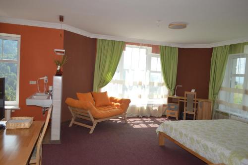 a bedroom with a bed and a chair and window at Дбайлива Ципа in Mizhhirʼʼya