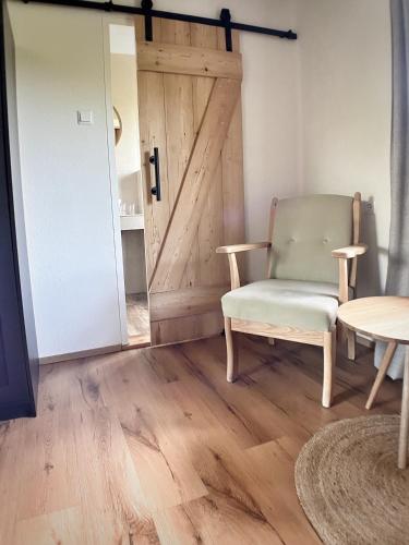 a room with a door and a chair and a table at Gasthof Auwirt in Sankt Michael im Lungau