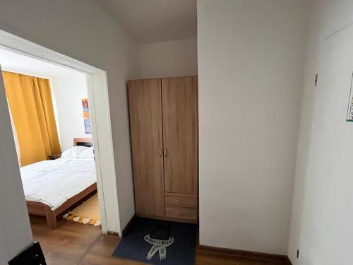 - une chambre avec un lit et une armoire en bois dans l'établissement Apartment, à Francfort-sur-le-Main