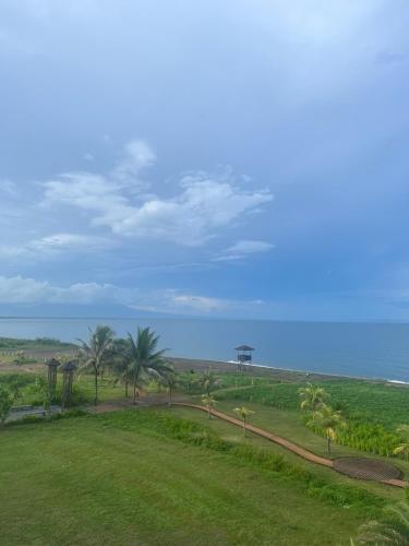 a park with palm trees and the ocean in the background at Seafront Residences Vacation Getaway in San Juan