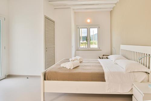 a white bedroom with a large bed with white pillows at B&B Villa Costanza in Lacona