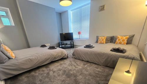 a bedroom with two beds and a television in it at Spacious ground floor suite comfortably sleeps up to eight in Halifax