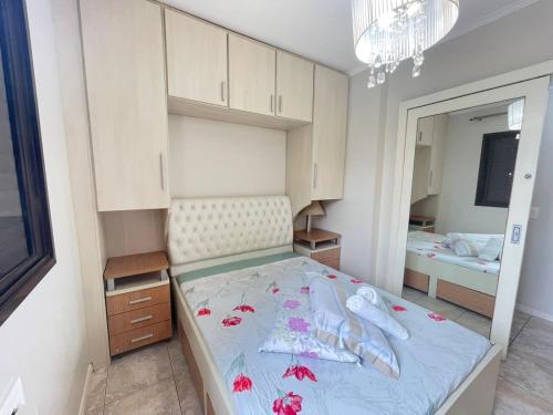 ein Schlafzimmer mit einem großen Bett und einem Spiegel in der Unterkunft Apto a 30m da praia sobre shopping Atlântico in Balneário Camboriú