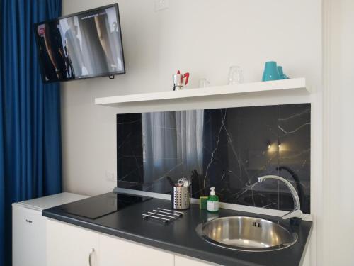 a kitchen with a sink and a black counter top at Villa Laura Residence Hotel Apartments & Studios in Ascea