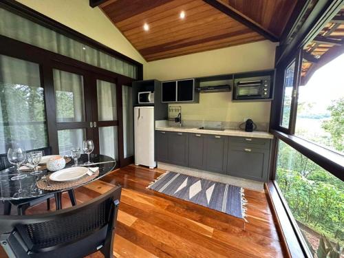 a kitchen with a dining table and a refrigerator at Pousada A Rosa e o Rei in São Francisco Xavier