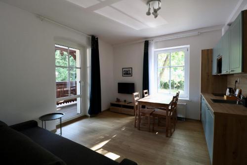 a living room with a table and a kitchen at Apartamenty Dębowa 3 in Polanica-Zdrój