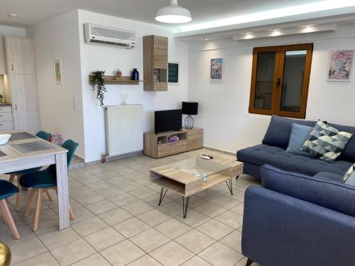 a living room with a blue couch and a table at Villa Lemonia in Malia