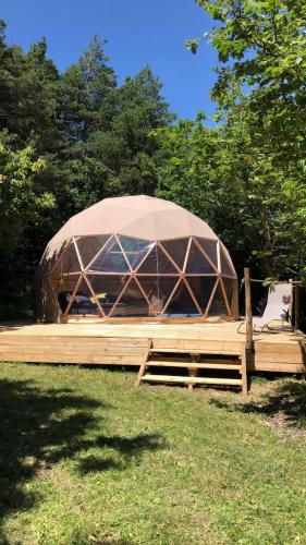 une grande tente en forme de dôme installée dans un champ d'herbe dans l'établissement SIMBIOSIS. Agri Cultur'Art Camp, à Pontinvrea