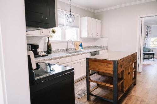 a kitchen with white cabinets and a black counter top at Walking Distance to Casino. in Danville