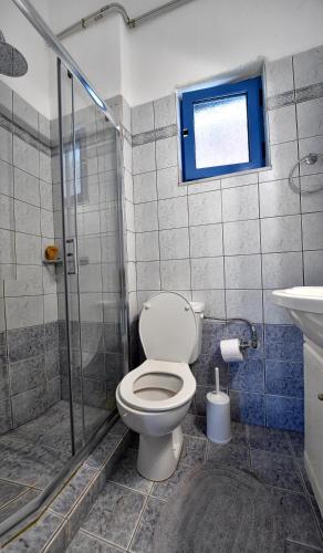 a bathroom with a toilet and a glass shower at Villa Elpida in Kanali
