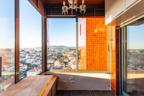 a room with a large window with a view of a city at Home with a view in Estoril