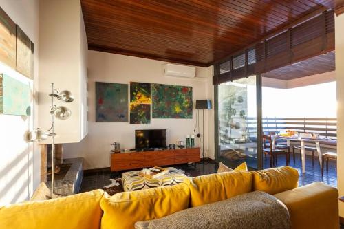 a living room with a yellow couch and a table at Atlantic Views Luxury Retreat in Estoril
