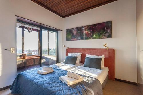 a bedroom with a large bed with two pillows on it at Home with a view in Estoril