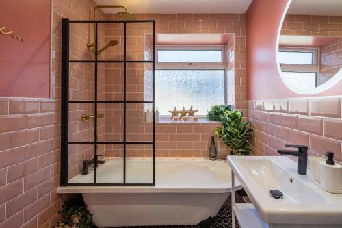 Baño de color rosa con bañera y lavamanos en Lake View Retreat, Pet Friendly, Free Parking, Lake View, Golf nearby, en Bowness-on-Windermere