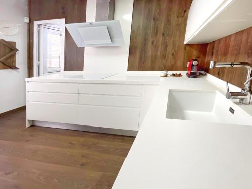 Una cocina con gabinetes blancos y un fregadero. en KS Toyo Golf - Kaleria Suites, en Retamar