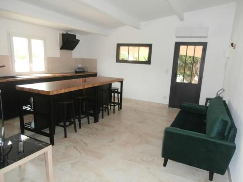 - un salon avec une table et une chaise verte dans l'établissement gîte à Caromb ( Mt Ventoux ), à Caromb