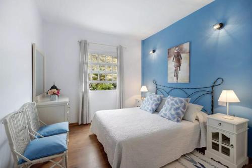 1 dormitorio azul con 1 cama y 1 silla en Apartamento El Zumacal, en Breña Baja