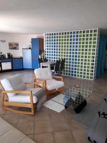a living room with two chairs and a table at Charly Point Villa in Methoni