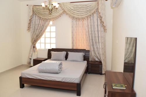 a bedroom with a bed and a window at Red-37 - Bn Breek Villa in Salalah