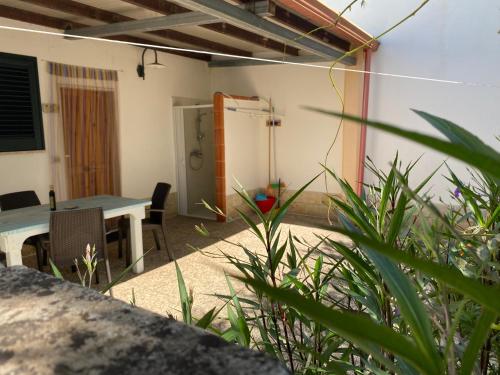 un patio con tavolo e sedie in una casa di Agriturismo Il Piccolo Lago a Otranto