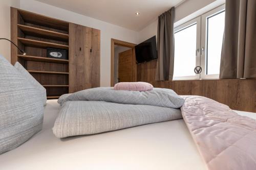 a bedroom with a large bed with a tv on it at Bergmadl Apartments in Neustift im Stubaital