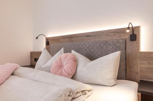 a bed with white pillows and a pink head board at Bergmadl Apartments in Neustift im Stubaital