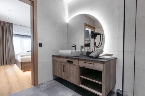 ein Bad mit einem Waschbecken und einem Spiegel in der Unterkunft Bergmadl Apartments in Neustift im Stubaital