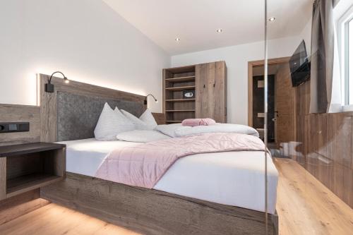 a bedroom with a large bed with a glass wall at Bergmadl Apartments in Neustift im Stubaital