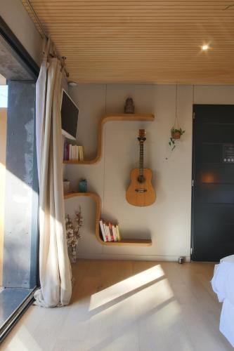 une chambre avec une guitare sur le mur dans l'établissement Bien Loin d'Ici Spa B&B, à Nîmes
