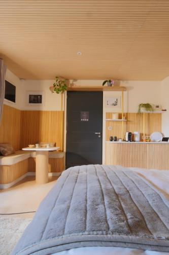 a bedroom with a black door and a table at Bien Loin d'Ici Spa B&B in Nîmes