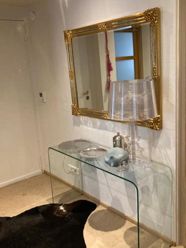 La salle de bains est pourvue d'un lavabo en verre et d'un miroir. dans l'établissement King size lounge 76m2 de confort au centre ville, à Mulhouse