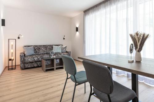 a living room with a table and chairs and a couch at Bergmadl Apartments in Neustift im Stubaital