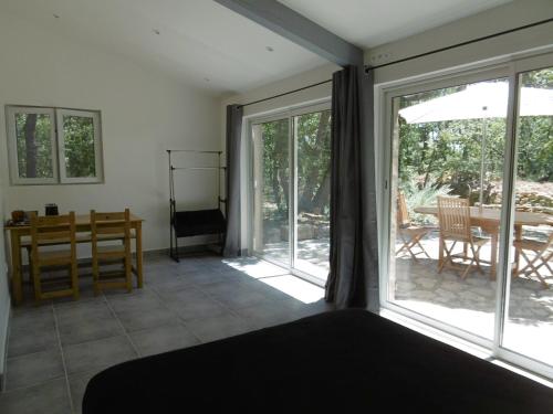 um quarto com uma cama e uma porta de vidro deslizante em Pied à terre au coeur du Luberon, Provence em Viens