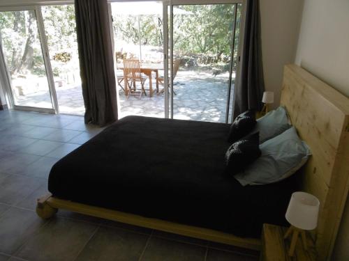um quarto com uma cama e vista para um pátio em Pied à terre au coeur du Luberon, Provence em Viens