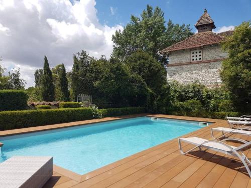 une piscine avec deux chaises et une maison dans l'établissement Domaine de La Monestarié - Teritoria, à Bernac