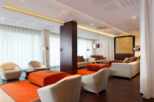 a living room with white chairs and a living room with at Adagio Nice Centre in Nice
