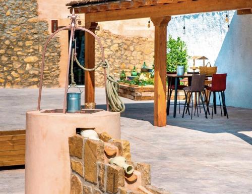 a stone fireplace in the middle of a patio at Hostal Foies de Baix in Relleu