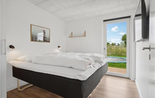 un grande letto in una stanza con una grande finestra di 5 Bedroom Pet Friendly Home In Brkop a Hvidbjerg