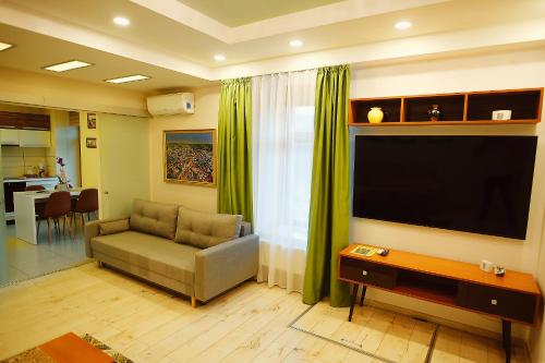 a living room with a couch and a flat screen tv at Magio Apartments in Turda