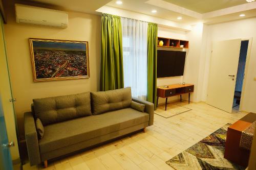 a living room with a couch and a television at Magio Apartments in Turda