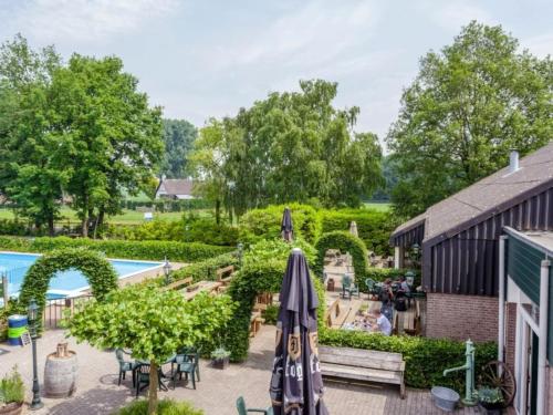 un patio al aire libre con sombrillas y una piscina en Riant huisje in bosrijke omgeving op chaletpark Kempenbos, en Diessen