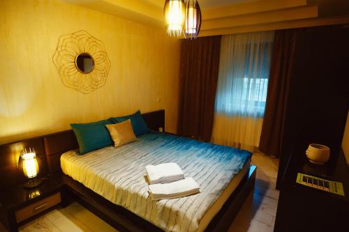a bedroom with a bed with towels on it at Magio Apartments in Turda