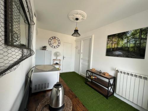 un salon avec tapis vert et une table dans l'établissement au coeur de la demeure, à Lieuran-lès-Béziers