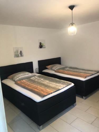 Duas camas individuais num quarto com um candeeiro. em Apartment Renate Strohhöfer em Hirschaid