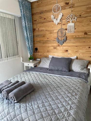 sypialnia z dużym łóżkiem i drewnianą ścianą w obiekcie Przytulny Apartament 100m od plaży w mieście Torrevieja