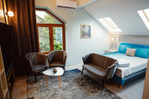 a bedroom with a bed and two chairs at Magio Apartments in Turda