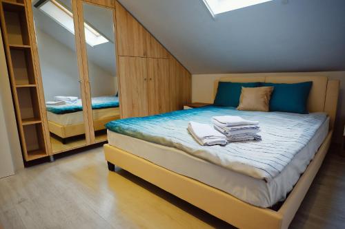 a bedroom with a bed with towels on it at Magio Apartments in Turda