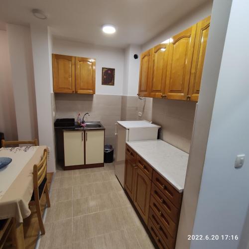 a small kitchen with wooden cabinets and a table at Milorad in Budva